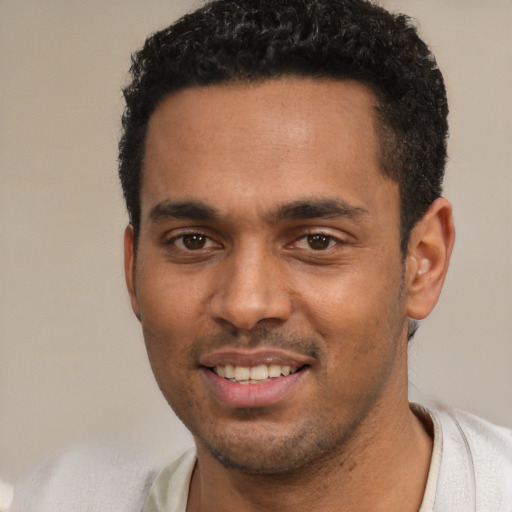 Joyful black young-adult male with short  black hair and brown eyes