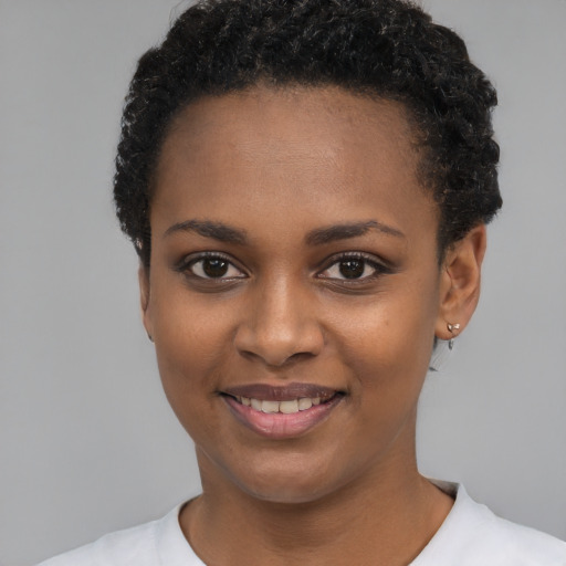 Joyful black young-adult female with short  black hair and brown eyes