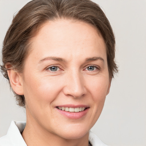 Joyful white adult female with short  brown hair and grey eyes