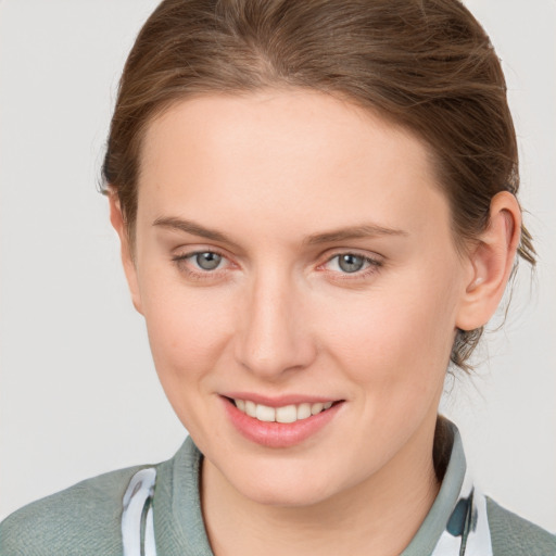 Joyful white young-adult female with medium  brown hair and grey eyes