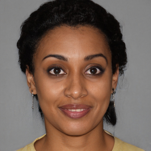 Joyful black young-adult female with short  black hair and brown eyes