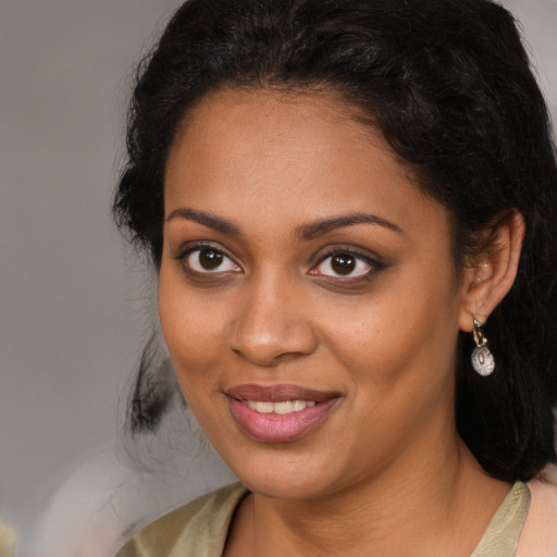 Joyful black young-adult female with long  brown hair and brown eyes