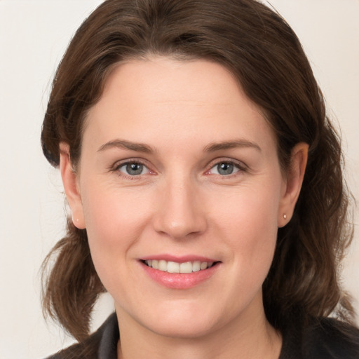 Joyful white young-adult female with medium  brown hair and grey eyes