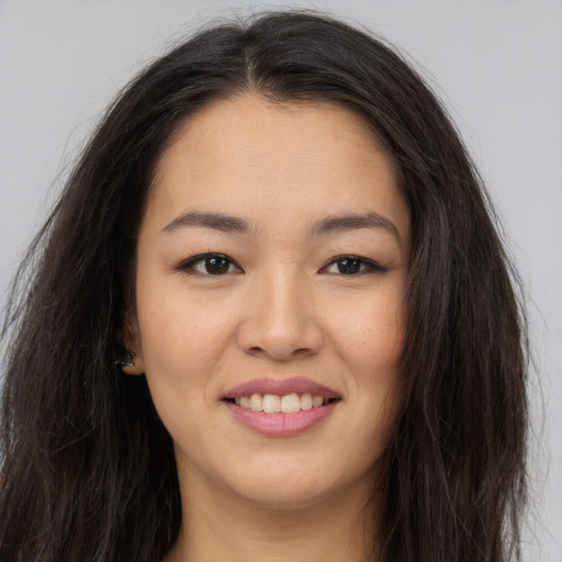Joyful asian young-adult female with long  brown hair and brown eyes