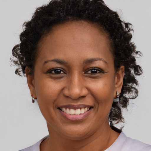 Joyful black adult female with short  brown hair and brown eyes