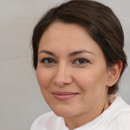 Joyful white adult female with medium  brown hair and brown eyes