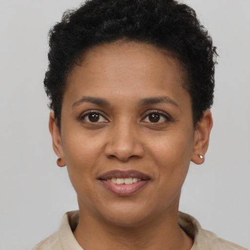 Joyful black young-adult female with short  brown hair and brown eyes