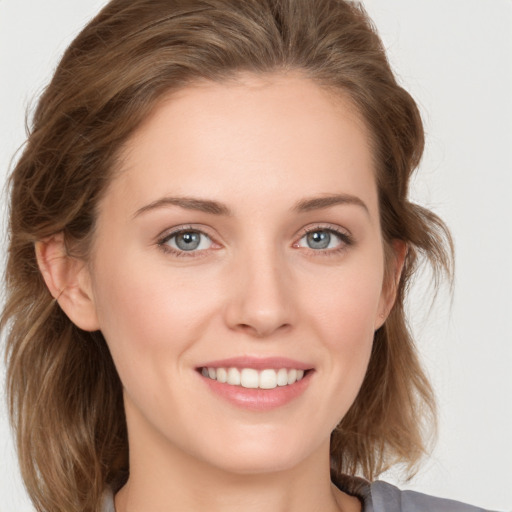 Joyful white young-adult female with medium  brown hair and grey eyes