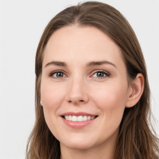 Joyful white young-adult female with long  brown hair and grey eyes