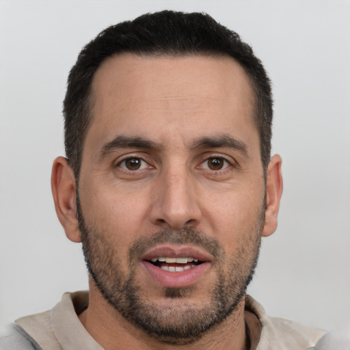 Joyful white adult male with short  black hair and brown eyes