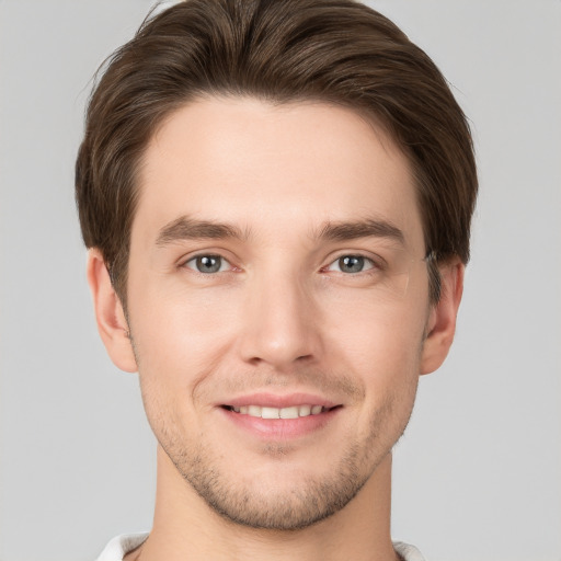 Joyful white young-adult male with short  brown hair and grey eyes