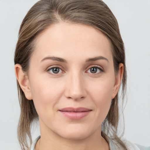 Joyful white young-adult female with medium  brown hair and grey eyes