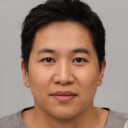 Joyful asian young-adult male with short  brown hair and brown eyes