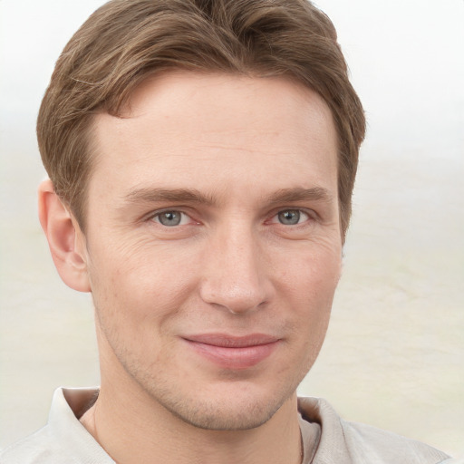 Joyful white young-adult male with short  brown hair and grey eyes