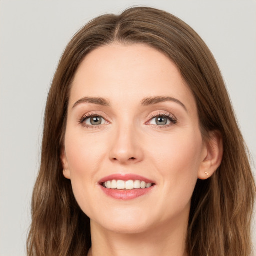 Joyful white young-adult female with long  brown hair and green eyes