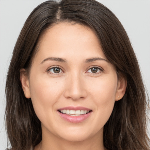 Joyful white young-adult female with long  brown hair and brown eyes