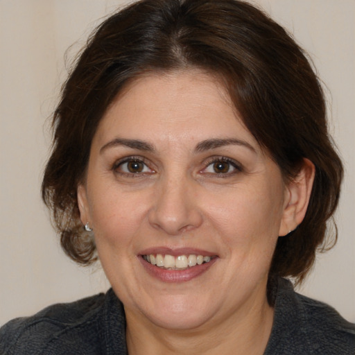 Joyful white adult female with medium  brown hair and brown eyes