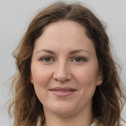 Joyful white adult female with long  brown hair and grey eyes