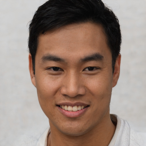 Joyful asian young-adult male with short  black hair and brown eyes