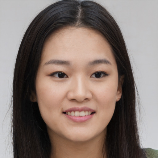 Joyful asian young-adult female with long  brown hair and brown eyes