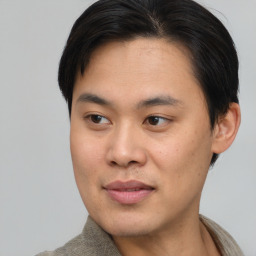 Joyful asian young-adult male with short  brown hair and brown eyes