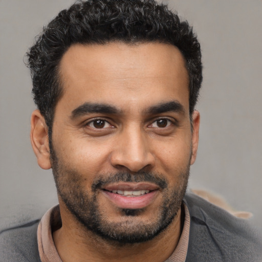 Joyful latino young-adult male with short  black hair and brown eyes