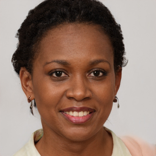 Joyful black young-adult female with short  brown hair and brown eyes