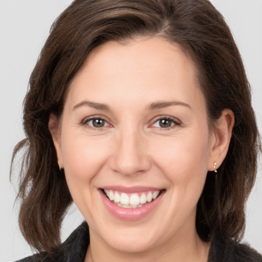 Joyful white adult female with medium  brown hair and brown eyes