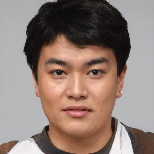 Joyful asian young-adult male with short  black hair and brown eyes