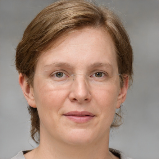 Joyful white adult female with medium  brown hair and grey eyes