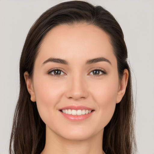 Joyful white young-adult female with long  brown hair and brown eyes