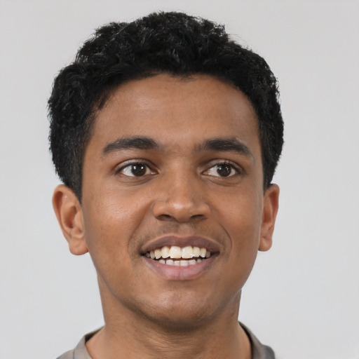 Joyful black young-adult male with short  black hair and brown eyes