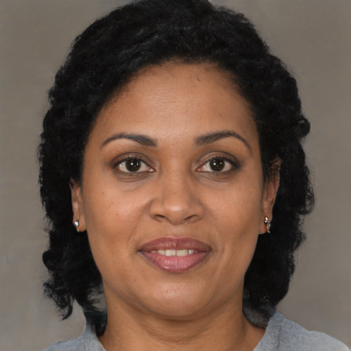 Joyful latino adult female with medium  brown hair and brown eyes