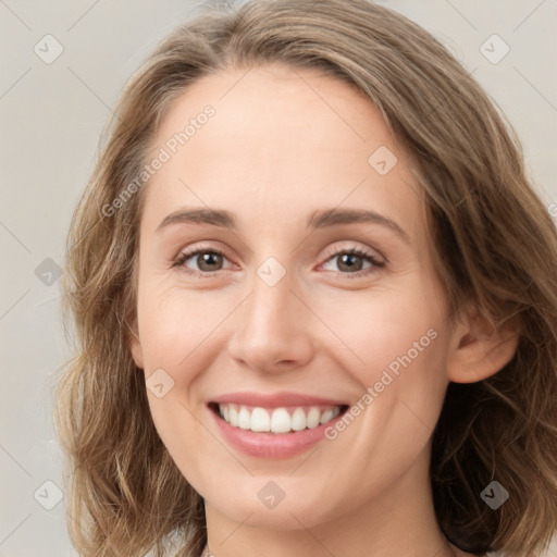 Joyful white young-adult female with medium  brown hair and green eyes