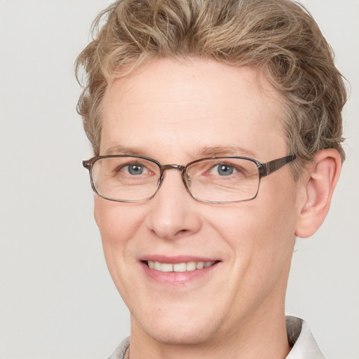 Joyful white adult male with short  brown hair and blue eyes