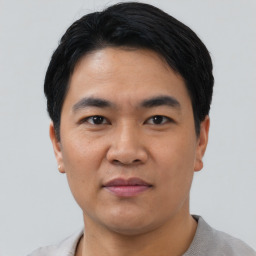 Joyful asian young-adult male with short  black hair and brown eyes