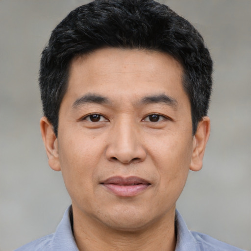 Joyful asian adult male with short  black hair and brown eyes