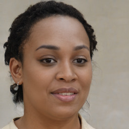 Joyful black young-adult female with medium  brown hair and brown eyes