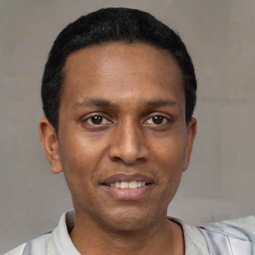 Joyful black young-adult male with short  black hair and brown eyes