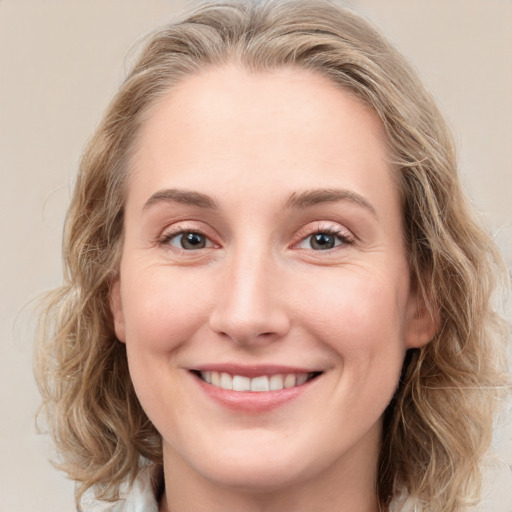 Joyful white young-adult female with medium  brown hair and blue eyes