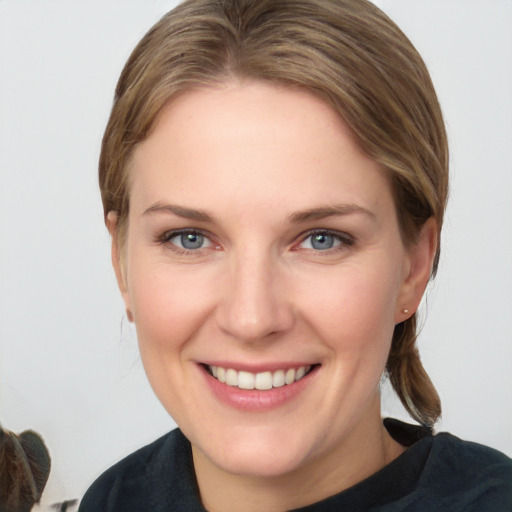 Joyful white young-adult female with medium  brown hair and grey eyes