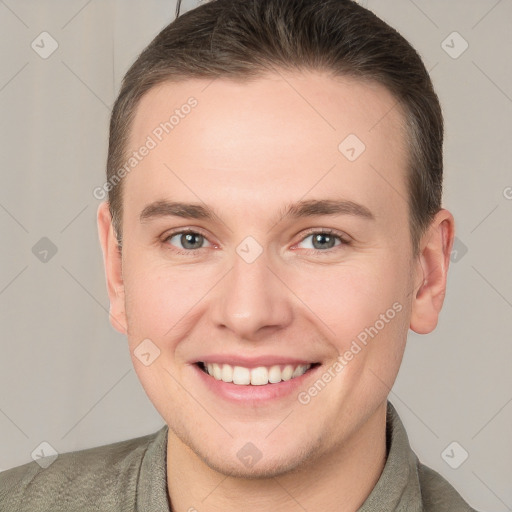 Joyful white young-adult male with short  brown hair and grey eyes