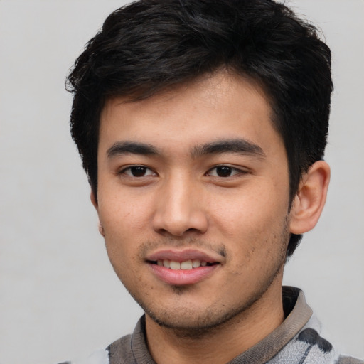 Joyful asian young-adult male with short  black hair and brown eyes