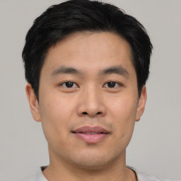 Joyful asian young-adult male with short  black hair and brown eyes