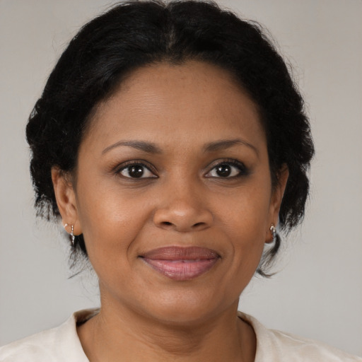 Joyful black adult female with short  brown hair and brown eyes