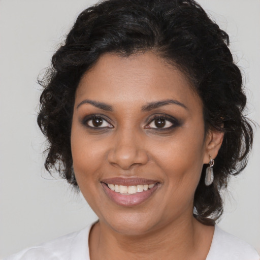 Joyful black young-adult female with medium  brown hair and brown eyes