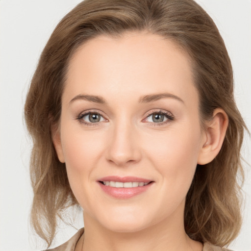 Joyful white young-adult female with medium  brown hair and grey eyes