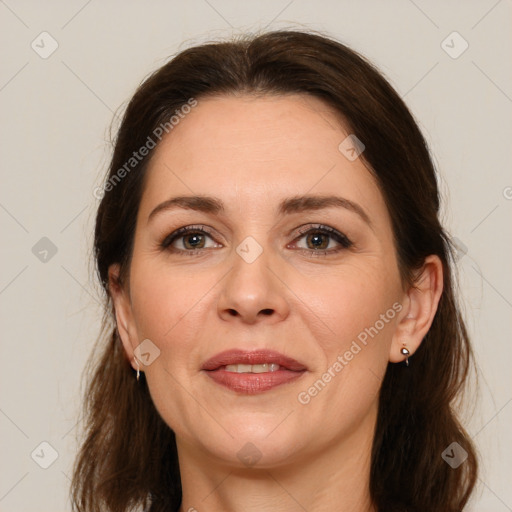 Joyful white adult female with long  brown hair and grey eyes