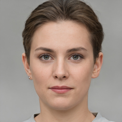 Joyful white young-adult female with short  brown hair and grey eyes