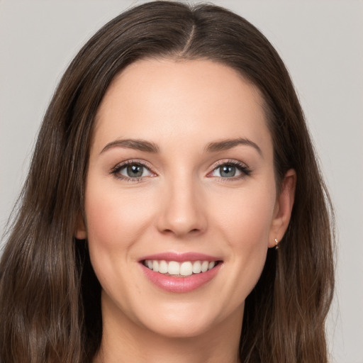 Joyful white young-adult female with long  brown hair and brown eyes